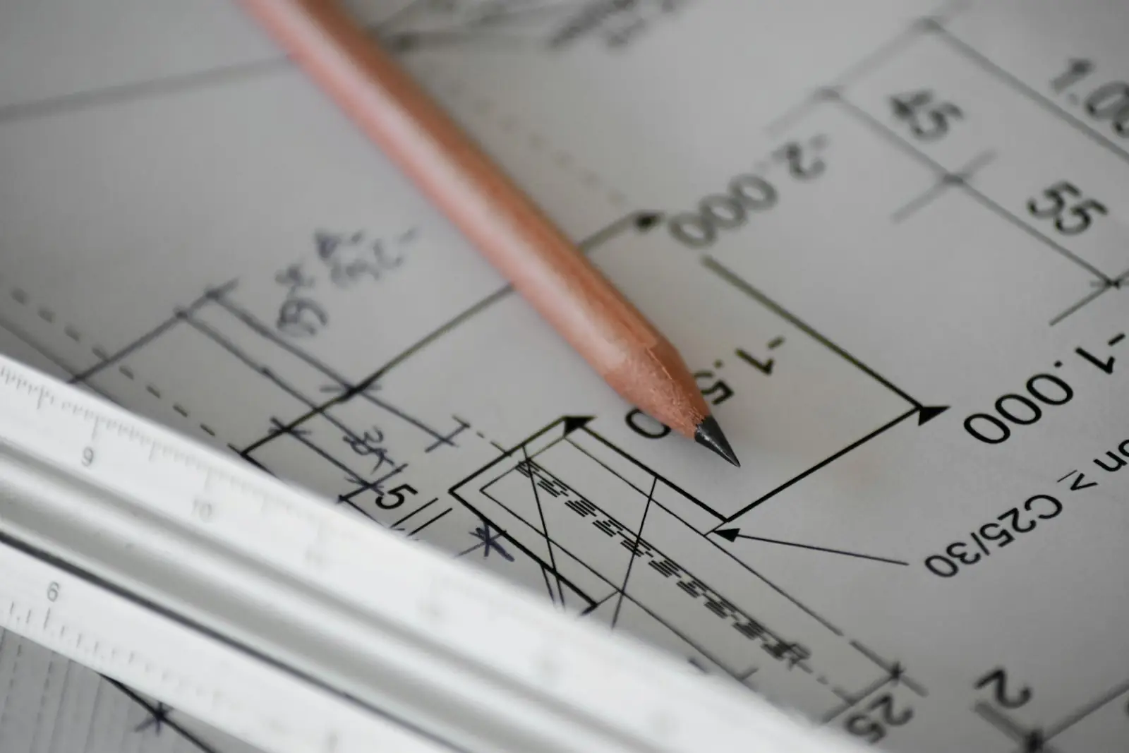 Plans techniques annotés et crayon posés sur une table de travail